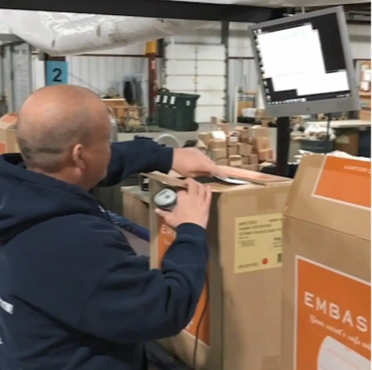 Warehouse worker scanning packages with handheld device in modern distribution center