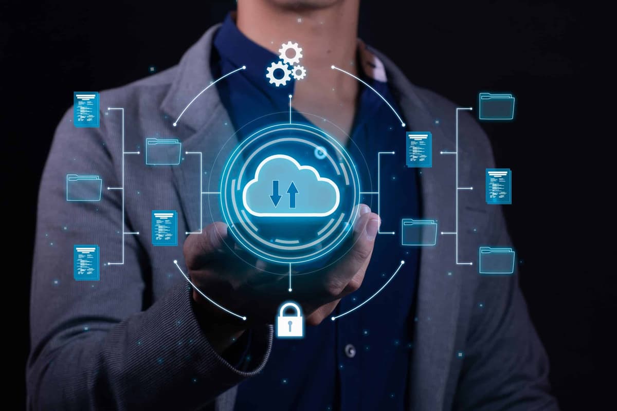Businessman holding holographic cloud computing interface with data storage and security icons