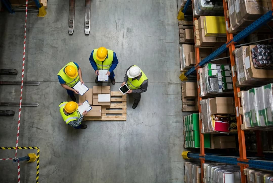 Warehouse workers conducting inventory inspection with forklift and storage shelves