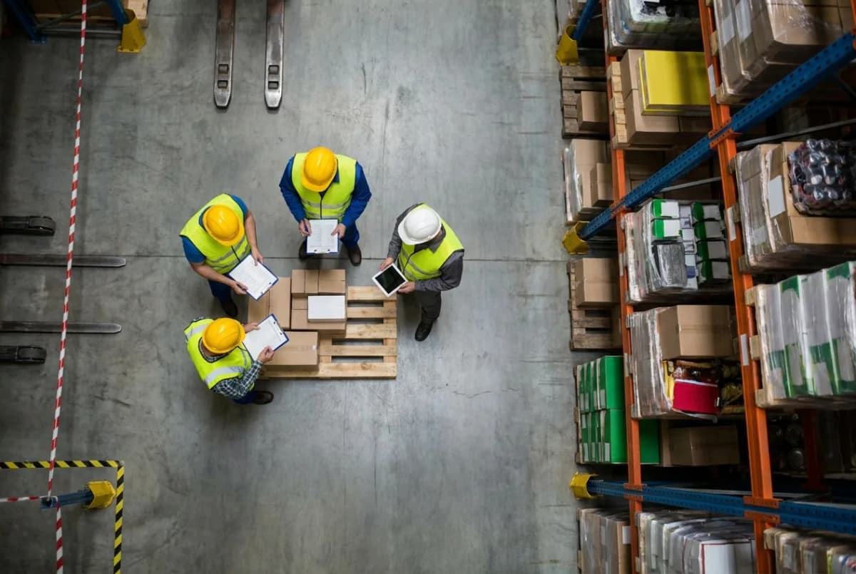 Warehouse workers conducting inventory inspection with forklift and storage shelves