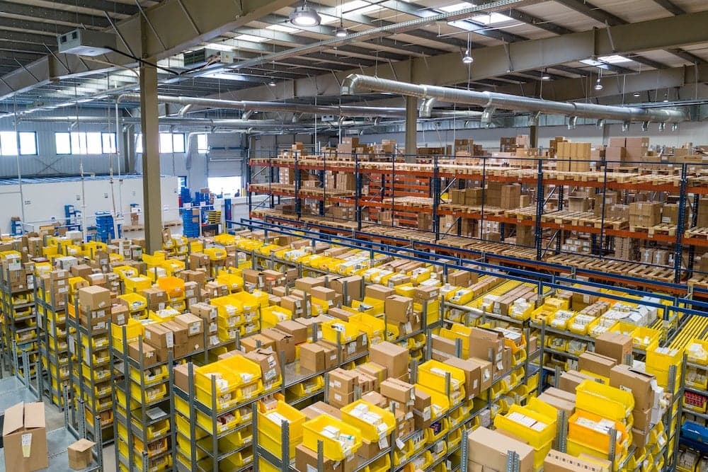Large warehouse interior with yellow storage shelves and organized cardboard boxes