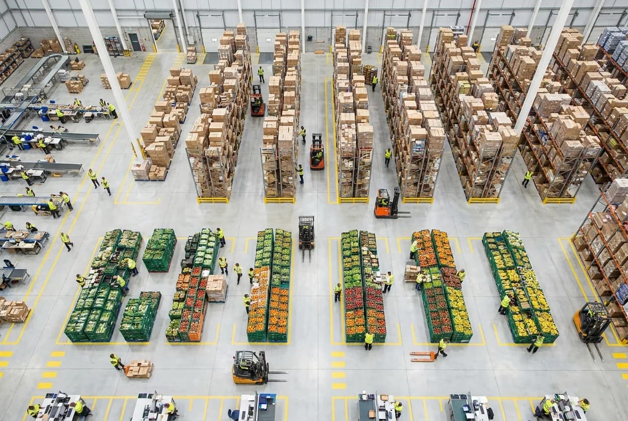 Male warehouse manager using tablet to track inventory in distribution center