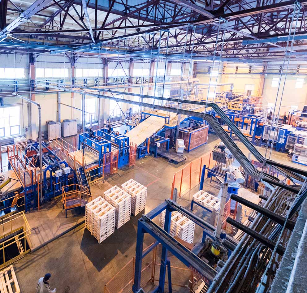 Modern industrial warehouse facility with conveyor systems and stacked wooden pallets
