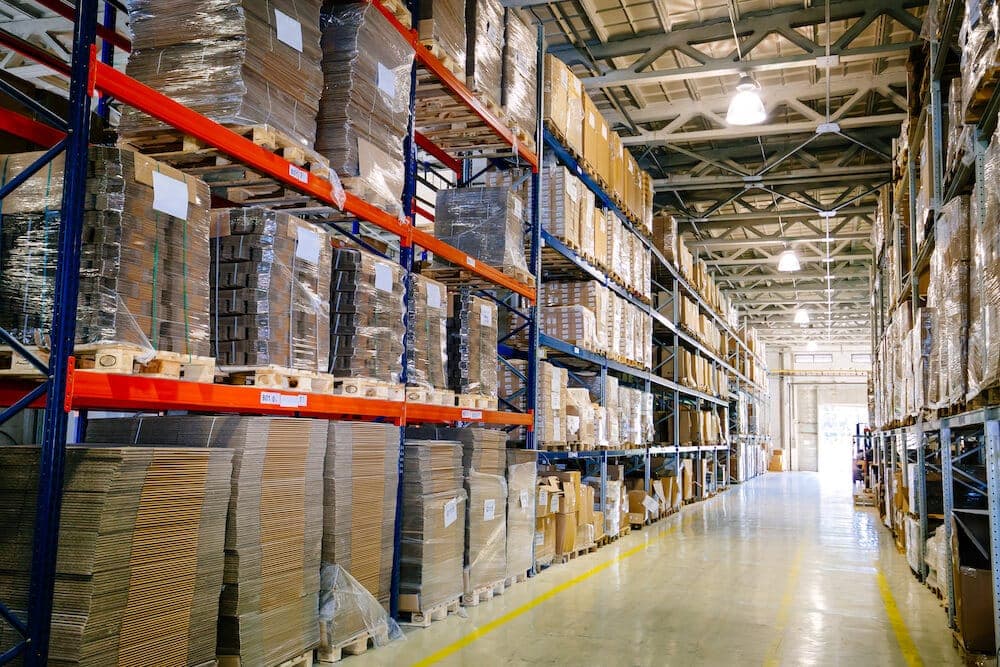 Modern warehouse interior with tall shelving racks storing palletized boxes and inventory