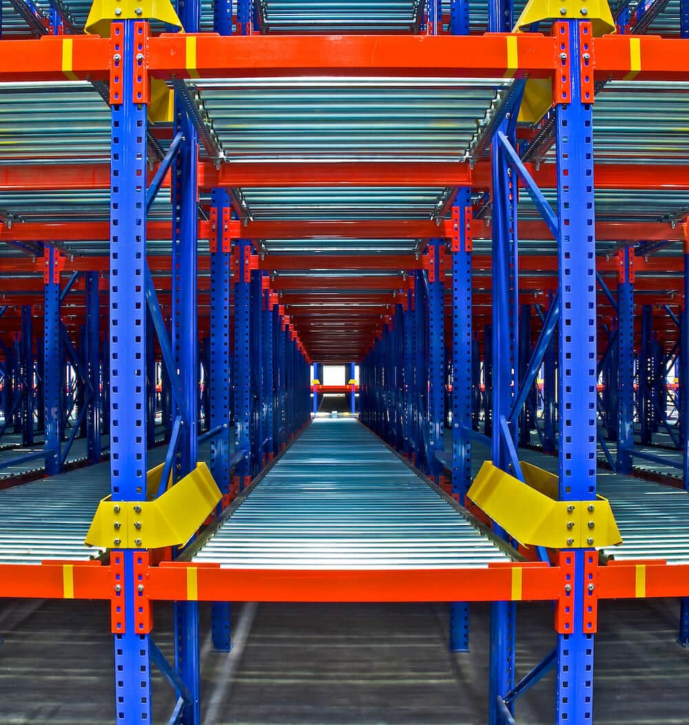 Industrial warehouse shelving system with blue frames, orange beams and roller conveyor tracks