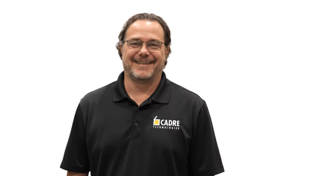 Professional man in glasses wearing black Cadre Technologies polo shirt smiling