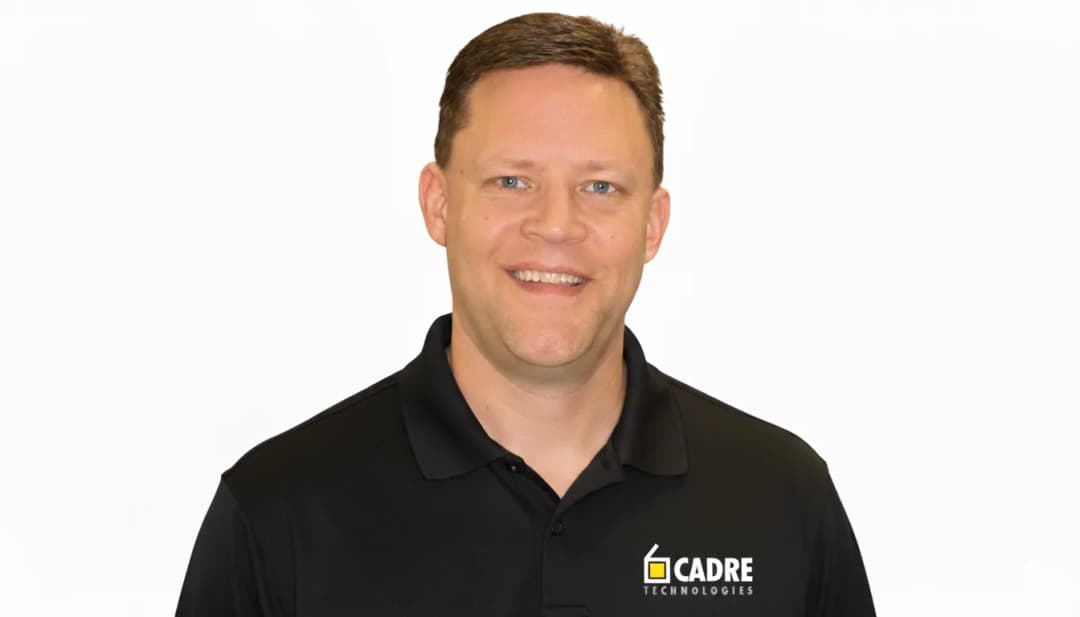 Professional man in black CADRE Technologies polo shirt smiling at camera