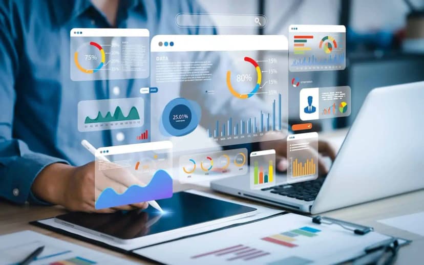 Business professional analyzing data dashboards and analytics charts on laptop and tablet