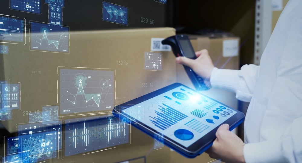 warehouse worker scanning a box with an RF scanner while holding a tablet
