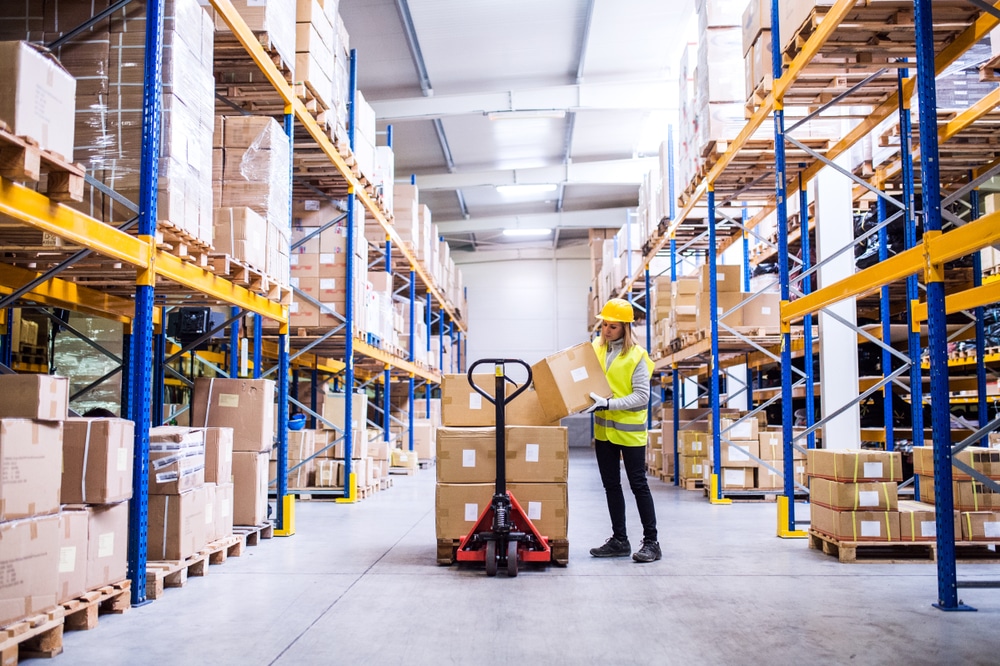 female warehouse worker setting box on pallet