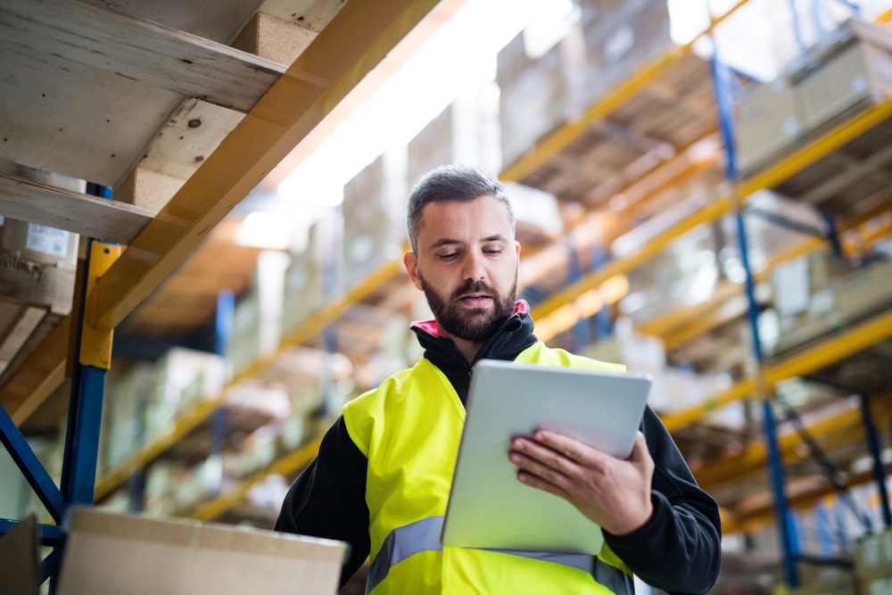 male warehouse worker using cadre technologies wms software tablet