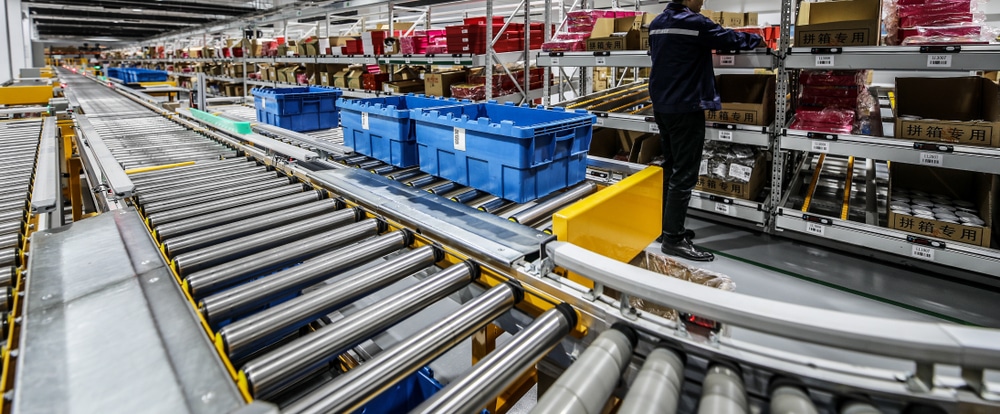 worker at a warehouse picking station near conveyor