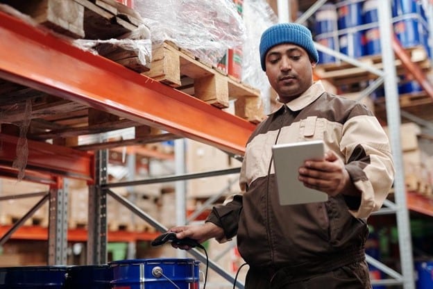 order picking in the warehouse - a worker scans a product.