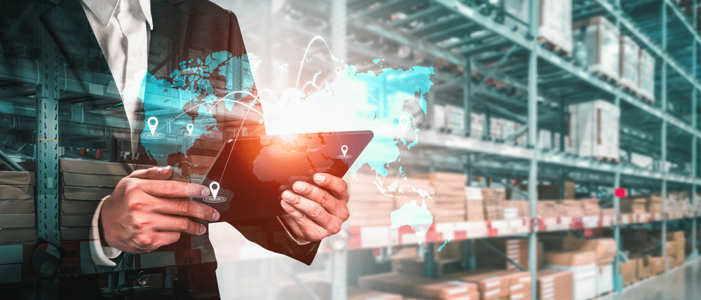 Man-in-warehouse-holding-tablet-with-supply-chain-visibility-software