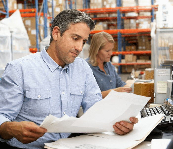 manager reviewing warehouse picking reports