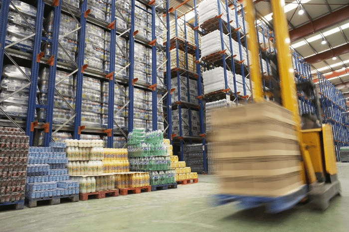 forklift moving a pallet of inventory in a warehouse