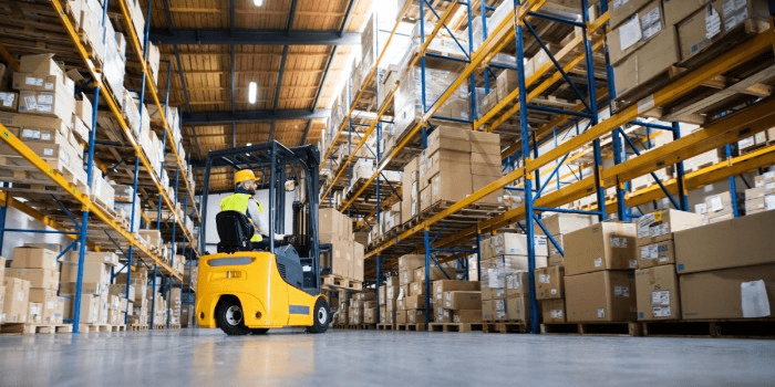 warehouse worker moving a pallet with a forklift