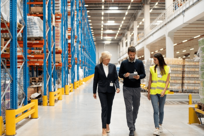 workers walking in a warehouse looking at a tablet