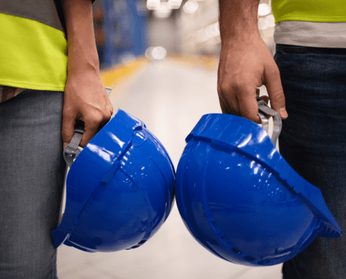 Two-warehouse-employees-with-safety-helmets-and-attire