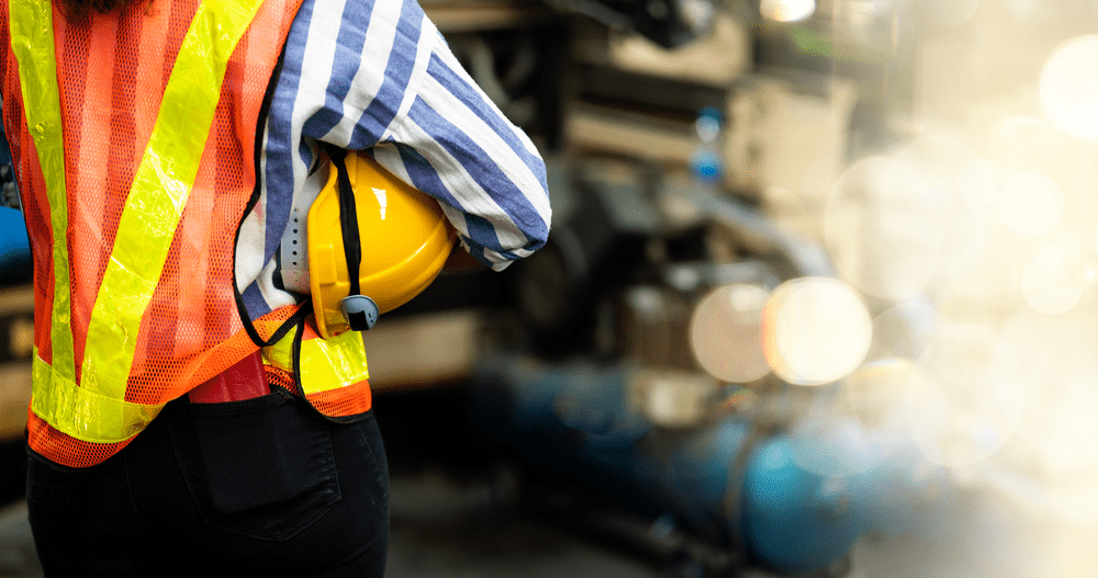 Warehouse-employee-holding-helmet-and-wearing-safety-vest