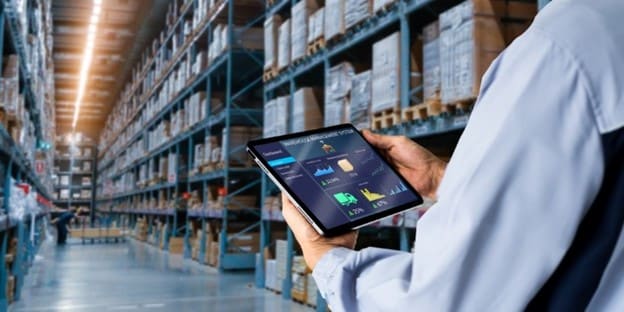 warehouse worker looking at reports on a tablet