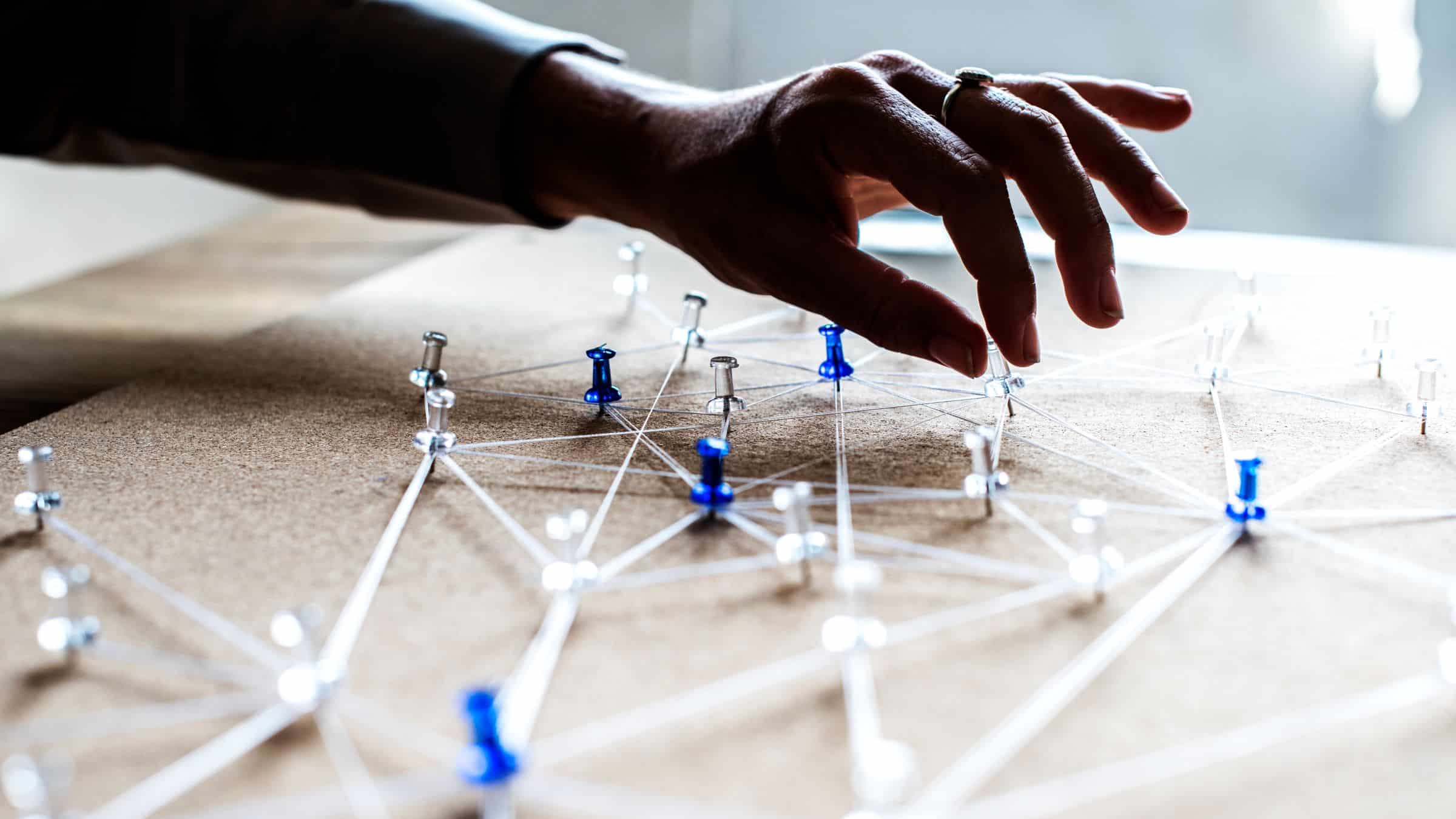 pushpins on a board connected with string