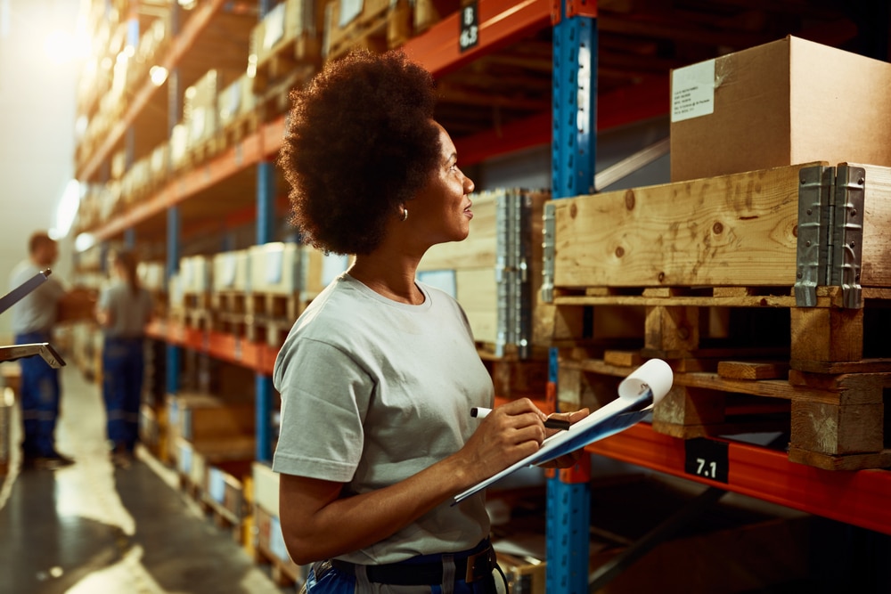 woman looking at the shelves with a clipboard