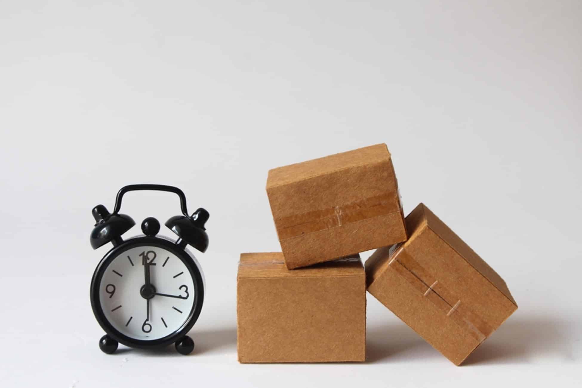 alarm clock next to a pile of boxes