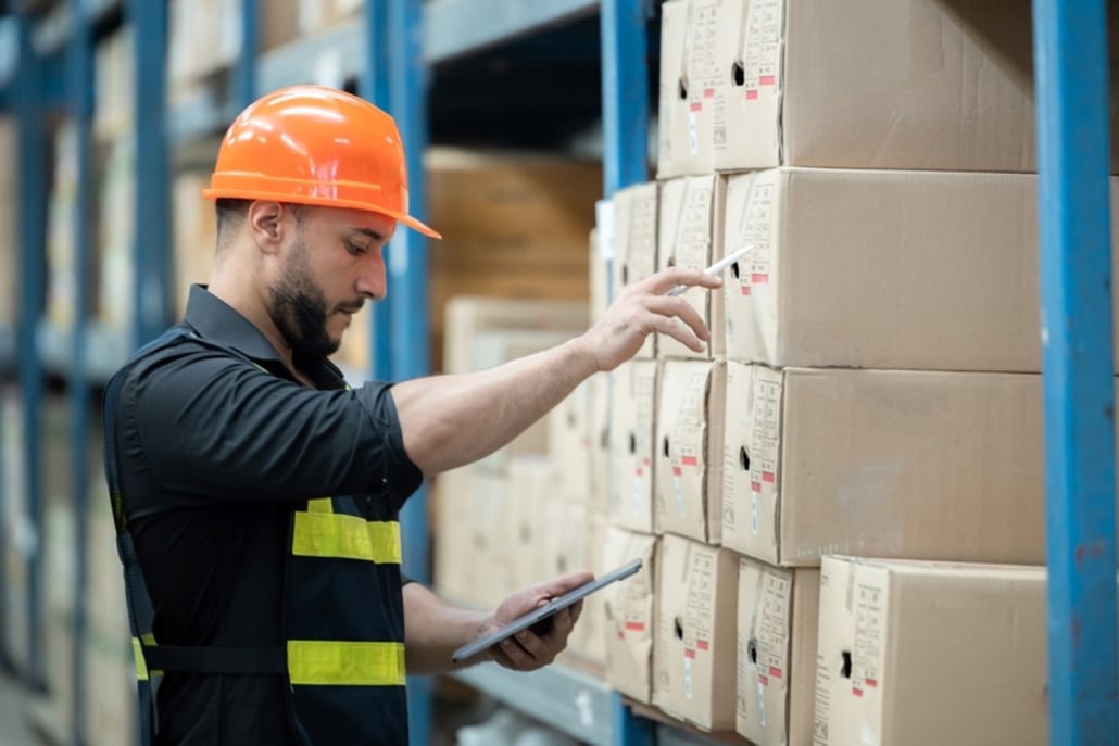 warehouse worker checking the box of an item in inventory