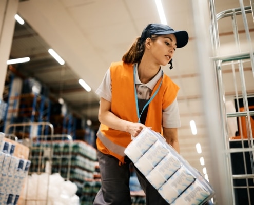 female-warehouse-worker-stacking-goods-on-a-rack-at a warehouse