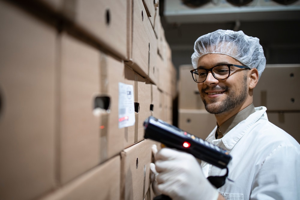 warehouse worker scanning a box barcode with an RF scanner