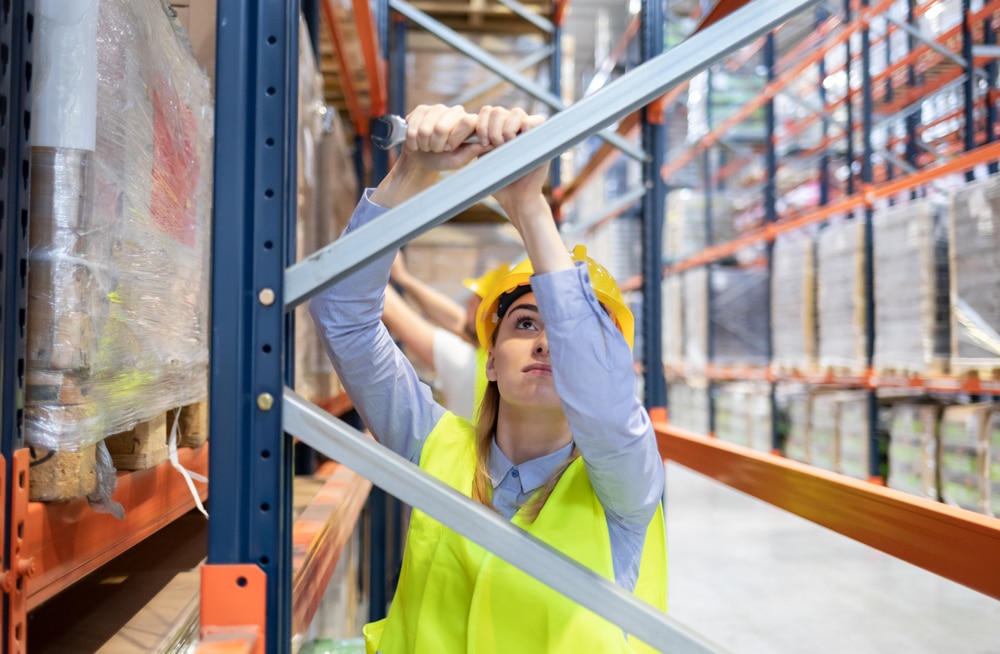 female worker assembling warehouse shelving