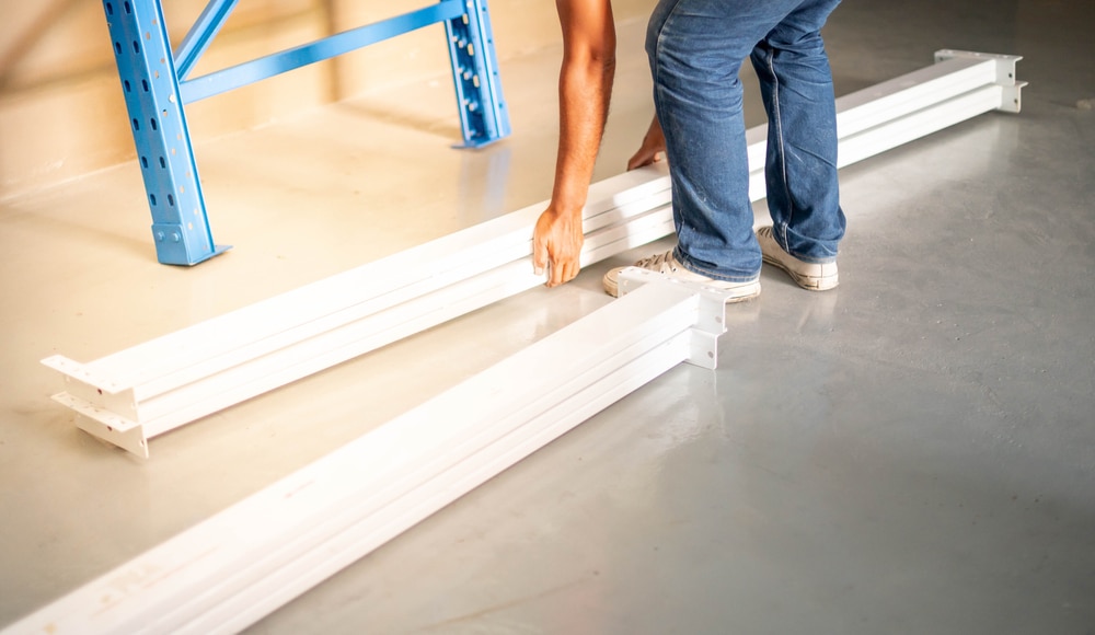 worker learning how to assemble warehouse shelving