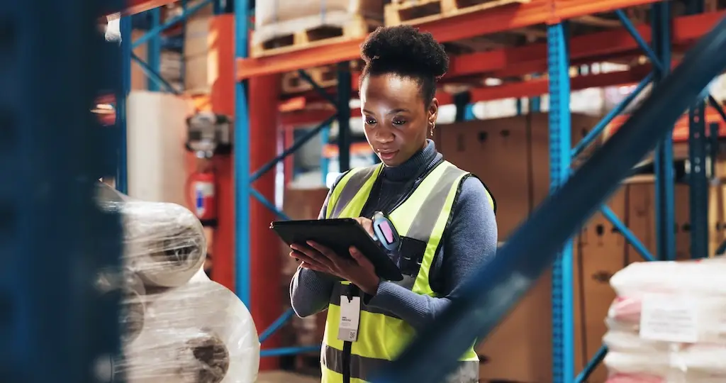 female warehouse worker using replenishment software tablet