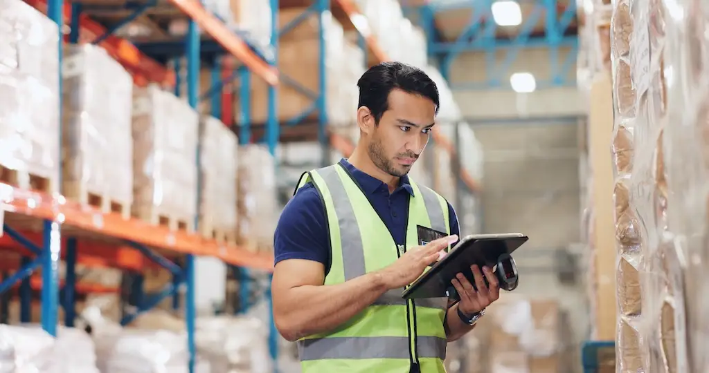 warehouse worker using inventory replenishment software