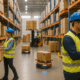 "Workers use handheld scanners on boxes with 1D and 2D barcodes in a modern warehouse."