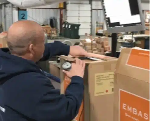 Warehouse worker scanning packages with handheld device in modern distribution center