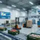Modern food supply chain warehouse with conveyor belts and robotic forklifts under bright lights, featuring real-time data displays.