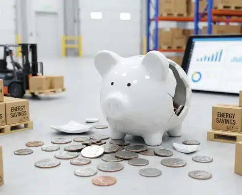 Broken white piggy bank with scattered coins representing budget-conscious warehouse efficiency solutions
