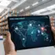 Tablet in warehouse showing supply chain visibility across regions