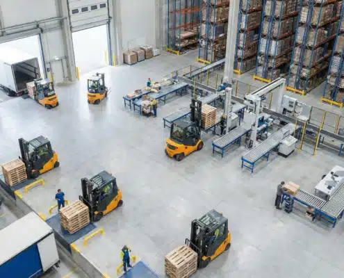Isometric warehouse facility showing putaway process with forklifts, storage racks, and loading dock