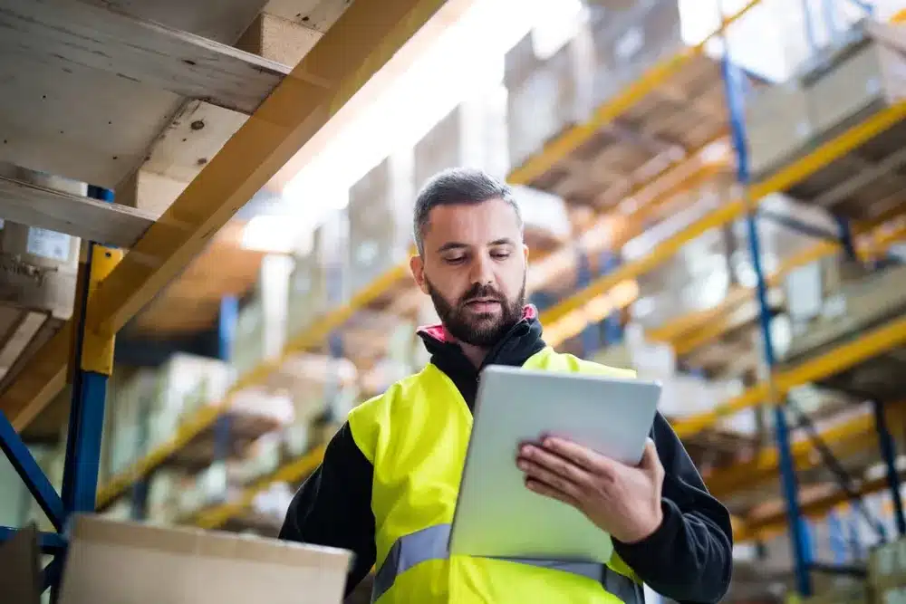 male warehouse worker using cadre technologies wms software tablet