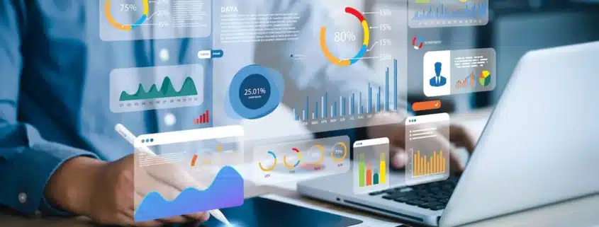 person on a laptop and tablet with icons floating in the showing what they are working on different charts and graphs
