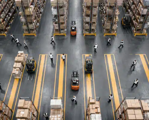 Warehouse floor with forklifts and aisles.